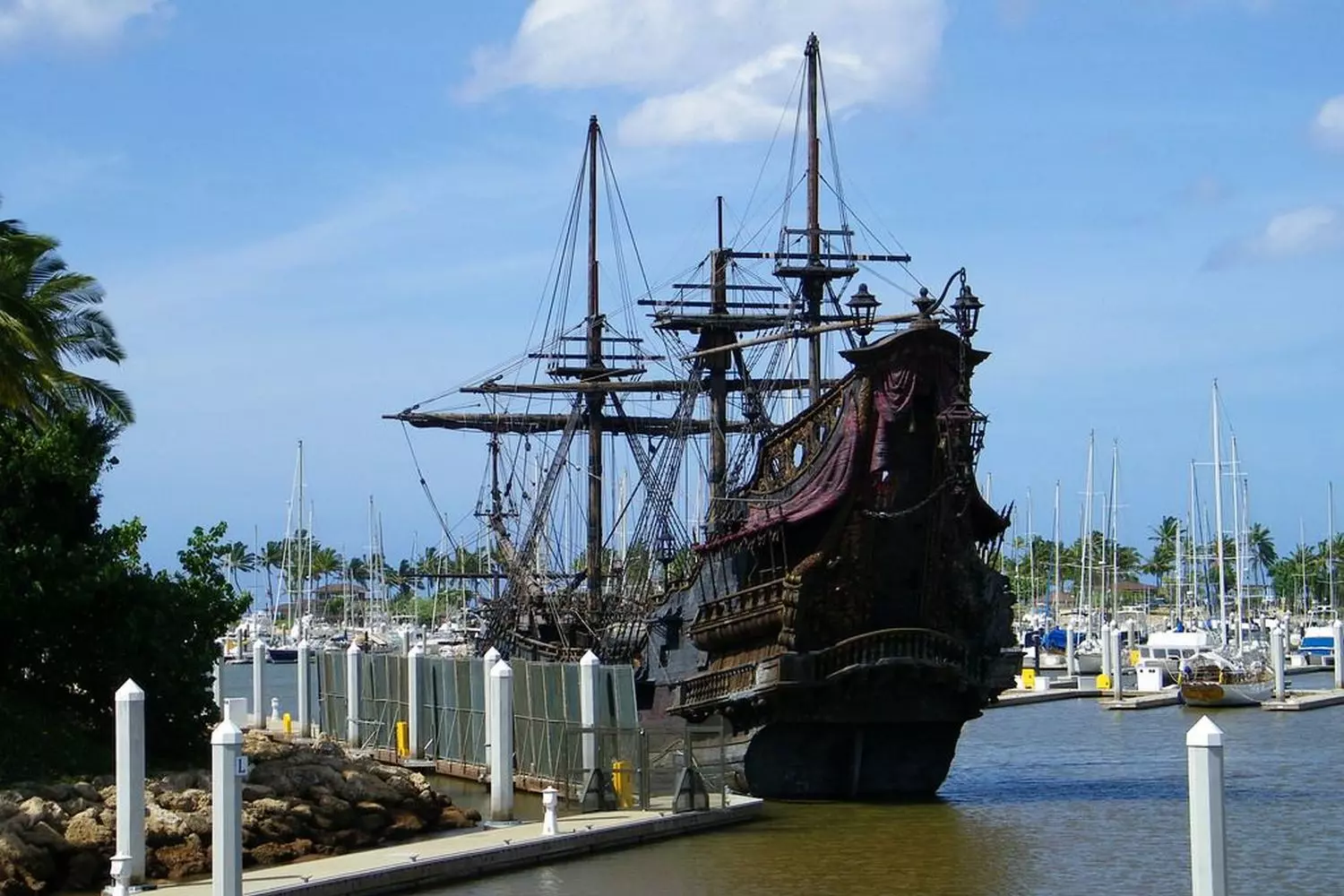 Legend of the Seas: Accurate Replica of Golden Age Pirate Ship Fully reconstructed historical pirate ship with wooden hull, raised sails and pirate flag, sailing on open sea or displayed in museum