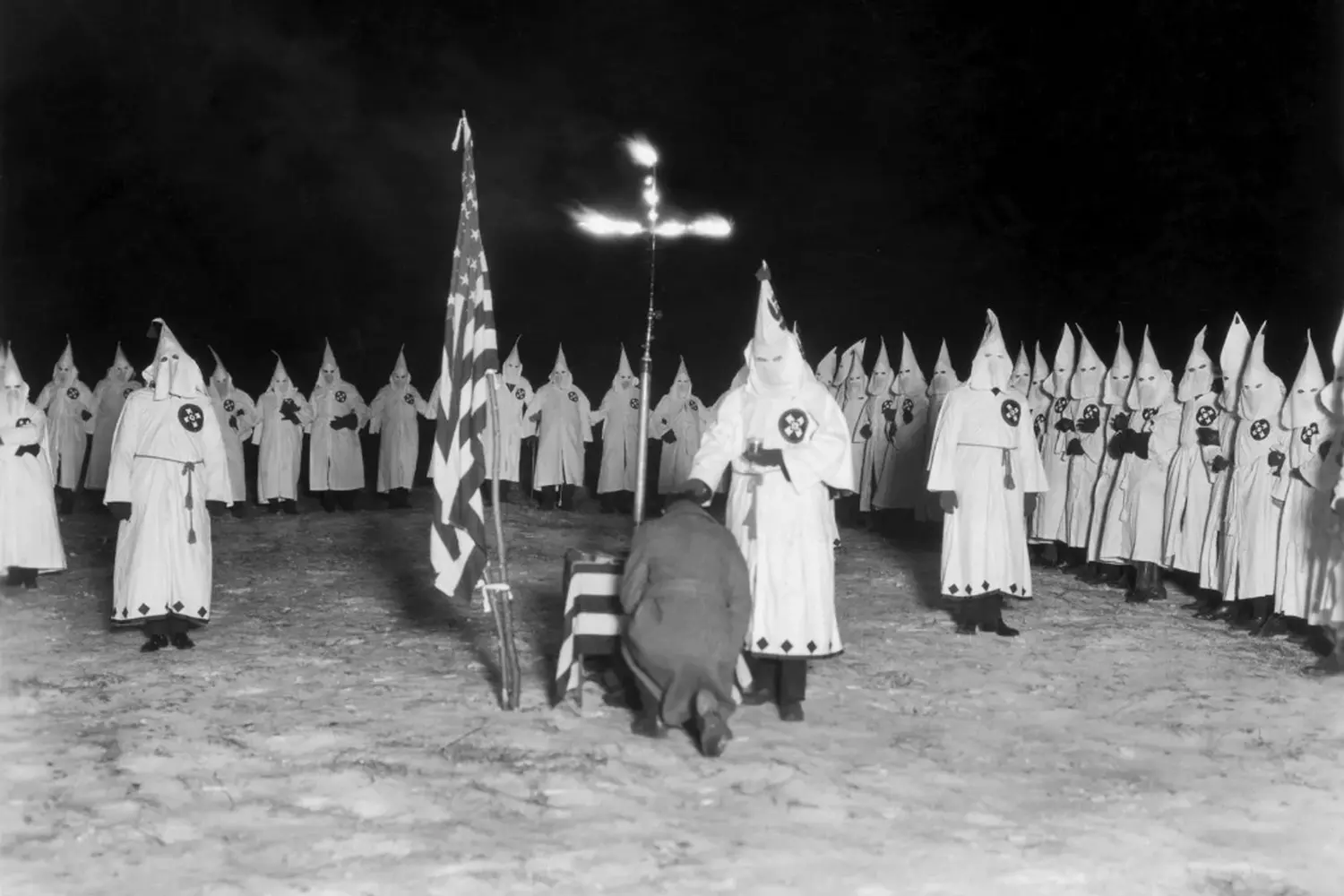 A meeting of the Ku Klux Klan (KKK) — a historical image of the racist group in the USA Historical photo of Ku Klux Klan members in white robes and hoods, symbolizing a racist and extremist organization