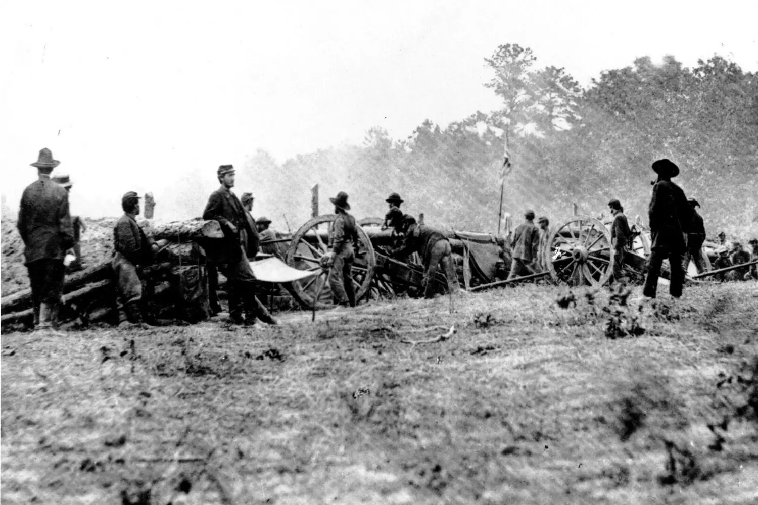 Soldiers in blue and gray uniforms fighting during the American Civil War, with smoke from cannon fire in the background Soldiers in blue and gray uniforms fighting during the American Civil War, with smoke from cannon fire in the background