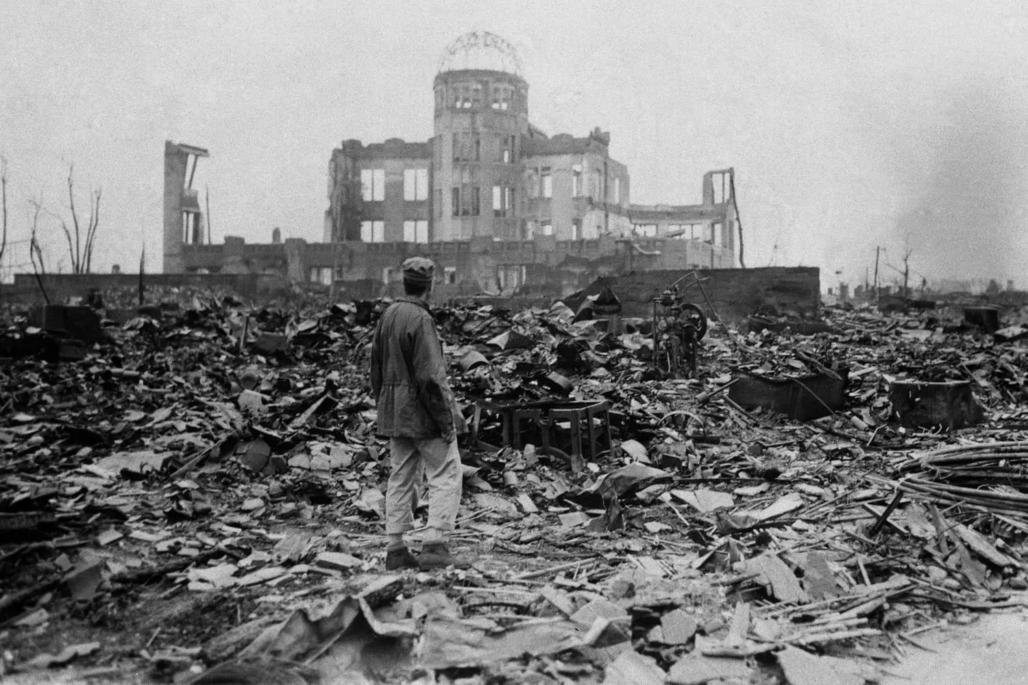 Silent Witness: A Person Before Hiroshima's Atomic Bomb Dome A solitary figure stands facing away from camera with the skeletal remains of the Hiroshima Peace Memorial (Genbaku Dome) in background