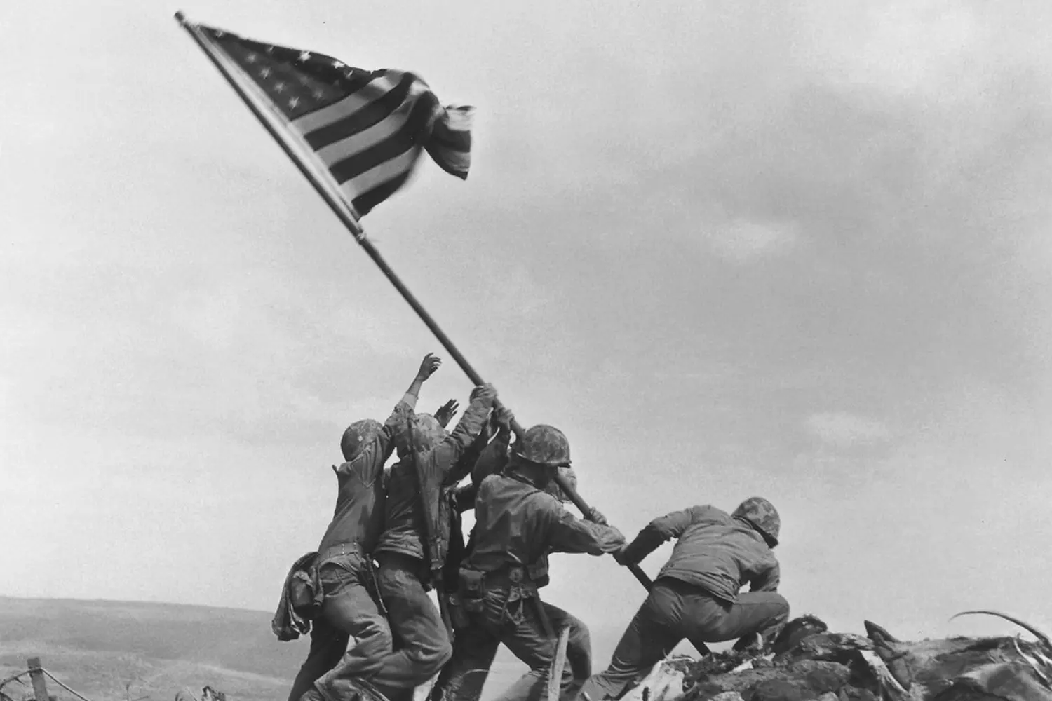 Raising Old Glory: US Soldiers Planting the Flag in WWII American GIs in combat gear raising the Stars and Stripes on captured ground