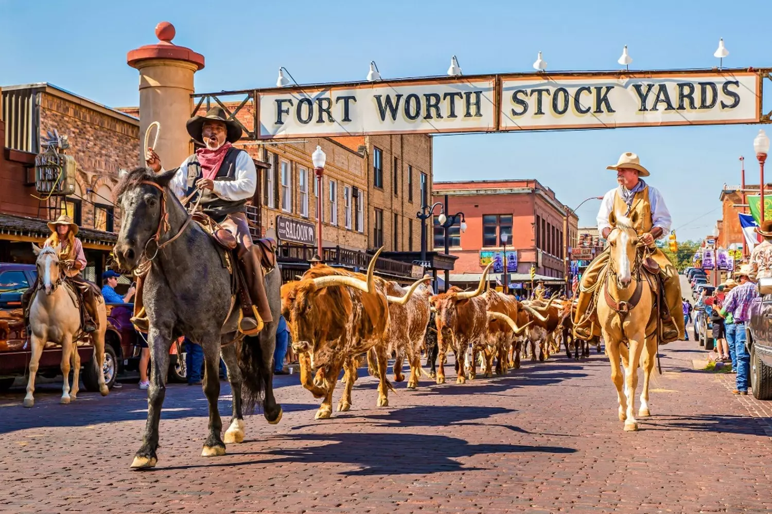 Historic Fort Worth Stockyards: A Walk Through the Old West A view of the brick-paved Exchange Avenue in the Fort Worth Stockyards National Historic District, with well-preserved red brick buildings, wooden sidewalks, and vintage signs, evoking the era of cattle drives