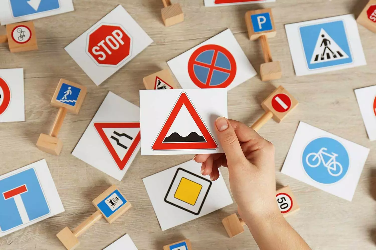 Учим дорожные знаки США: раскладываем все по полочкам Стол с разложенными цветными карточками дорожных знаков США для изучения ПДД