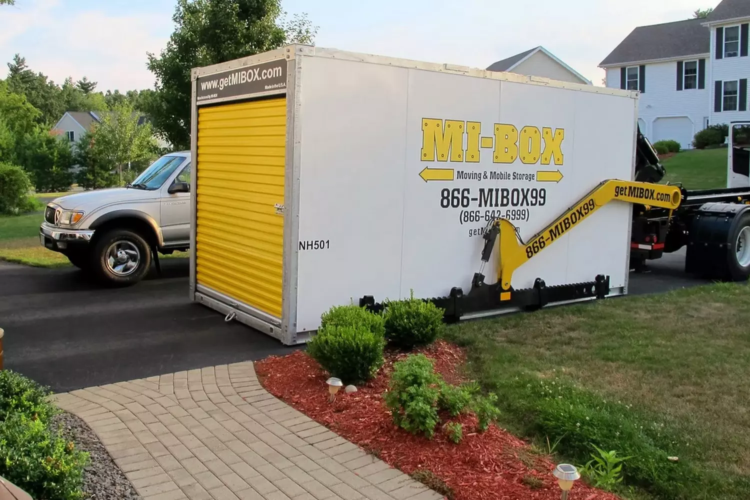 'We Pick Up' Mobile Storage Service: How it works in America Door-to-door storage service: a container being secured for transport from a residential home in the United States