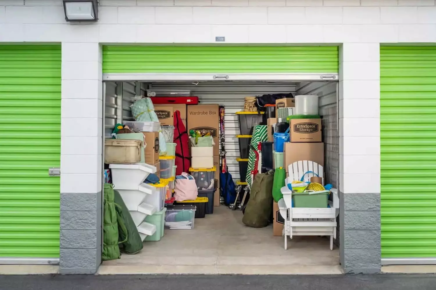 Loaded storage unit in the USA: efficient space organization for personal belongings Neatly organized possessions inside an American storage locker with furniture reaching to the ceiling