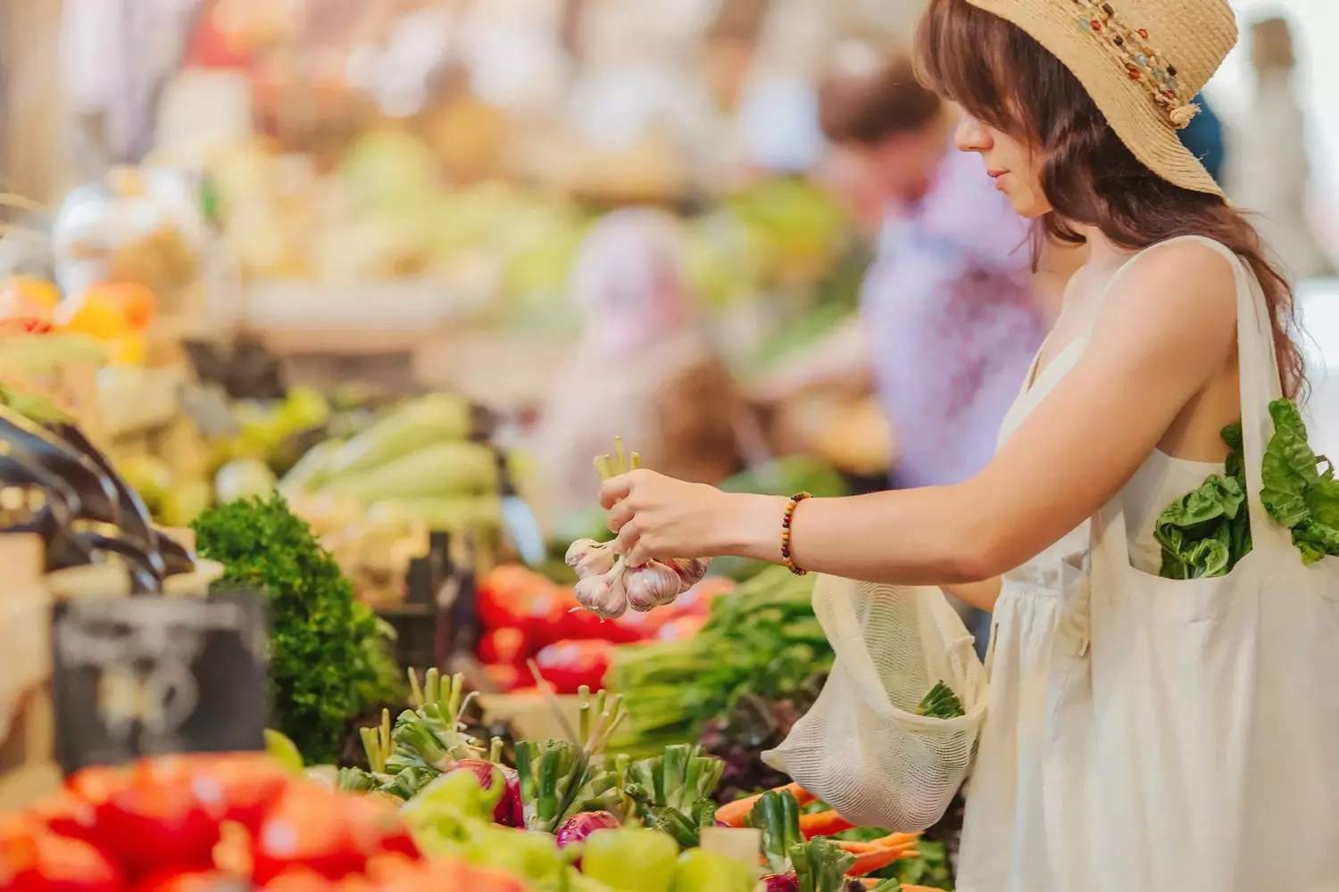 Девушка выбирает свежие продукты на фермерском рынке в США