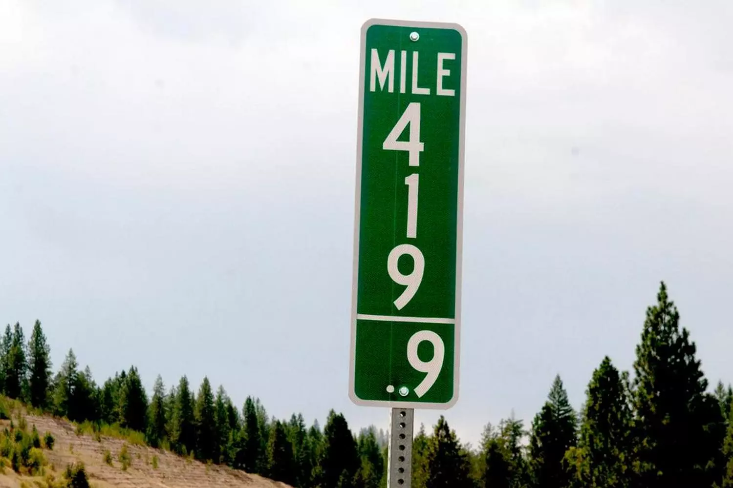 Miles to Go: Classic American Highway Distance Sign on a Scenic Route Vintage-style U.S. road sign displaying distance in miles, showcasing the iconic imperial measurement system on an open highway