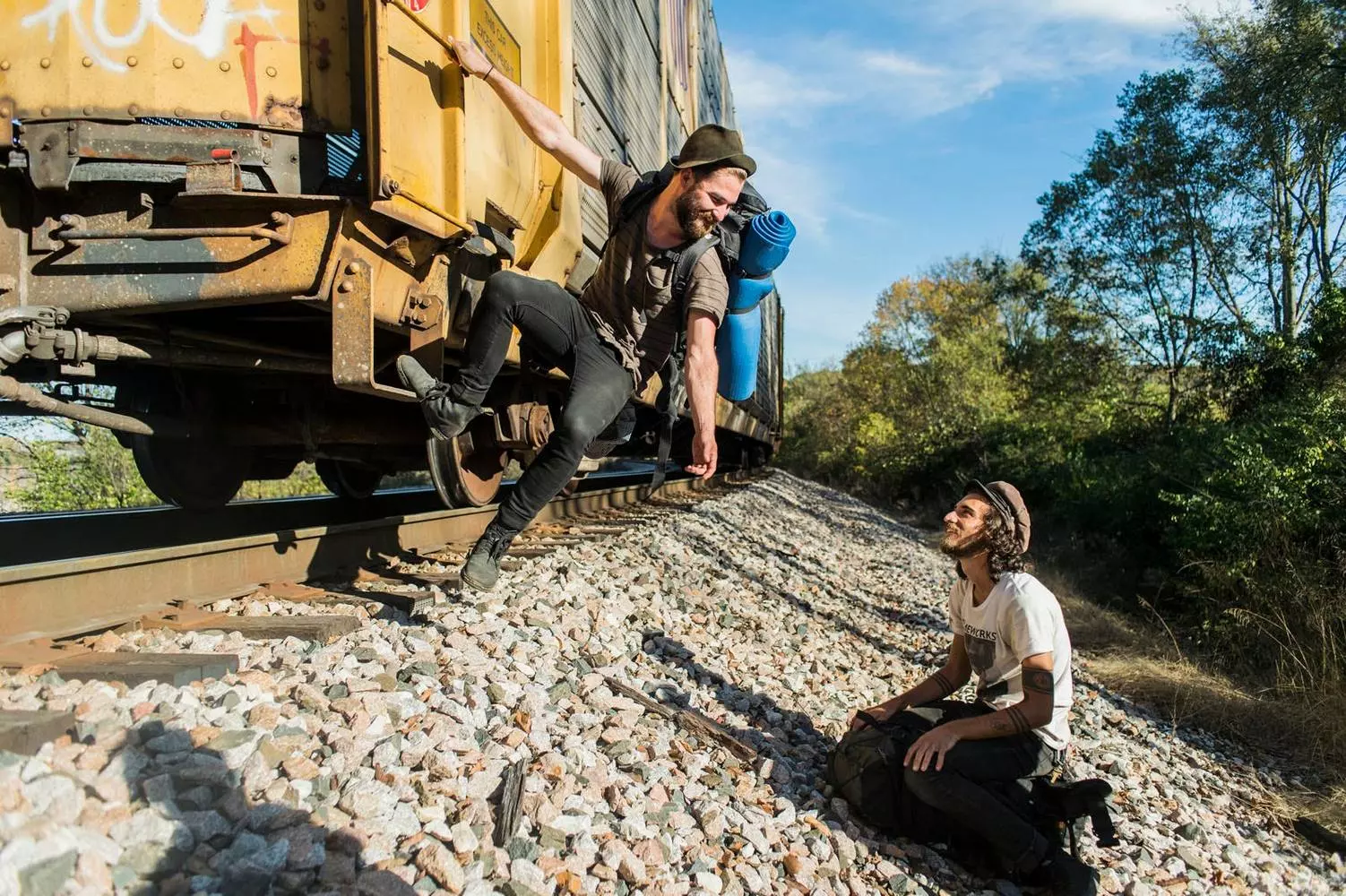 Freedom Beyond the Rules: The World of Modern American Trainhoppers A group of modern trainhoppers resting by a campfire next to a freight train somewhere in the USA
