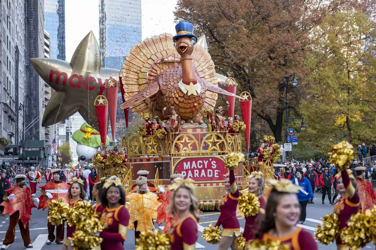 Colorful giant balloon characters from the Macy's Thanksgiving Day Parade float past New York City skyscrapers