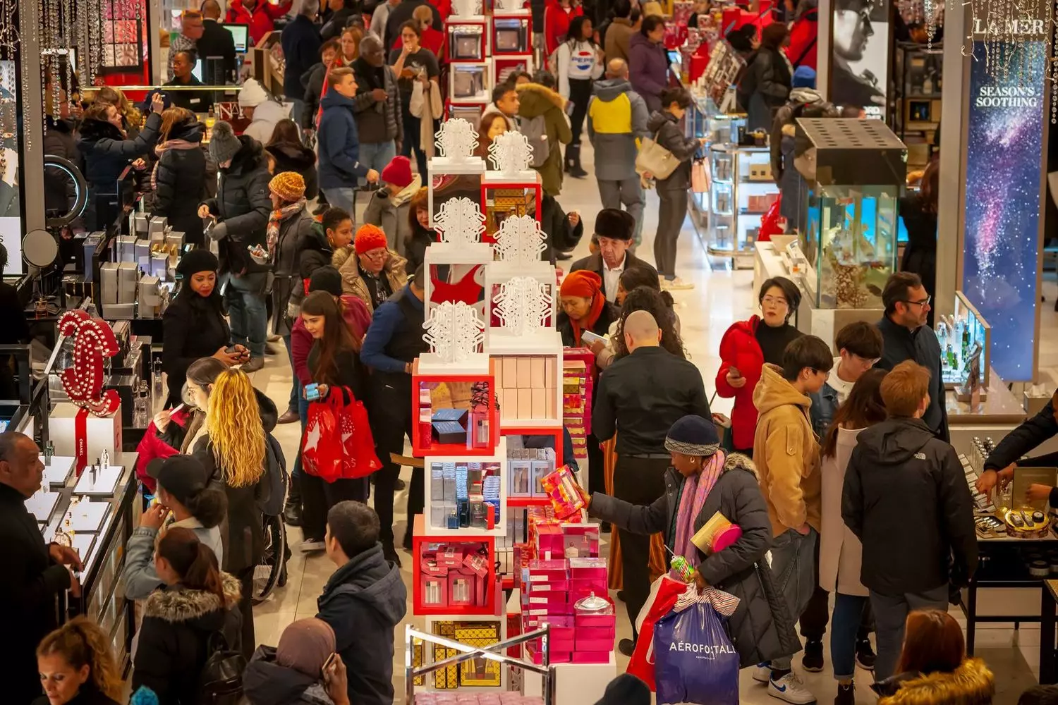 Panoramic view of a shopping center on Black Friday morning: crowds browsing stores, long queues, and seasonal decorations
