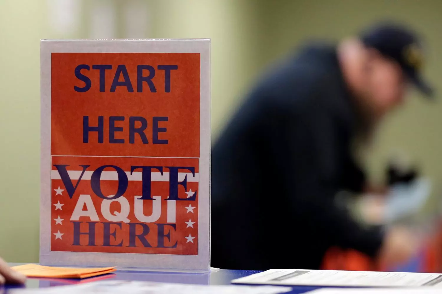 "Elections Begin Here" sign at a US polling station An official "Elections Begin Here" sign posted outside an American polling place, such as a school or community center, with the US flag visible
