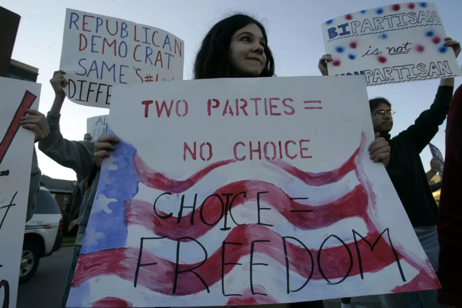 A young activist holds a sign "Two Parties Is Not A Choice" at a protest in the USA A determined young woman at a protest holds a handwritten sign that reads "Two Parties Is Not A Choice," criticizing the limitations of the American two-party system