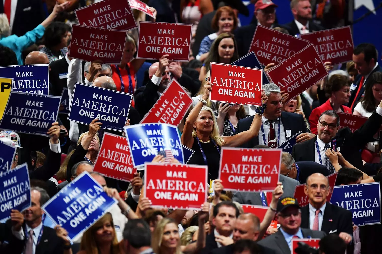 Political rally in the USA: people with election signs and American flags A diverse crowd of people at a political rally in the United States, holding handmade signs with election slogans and waving American flags