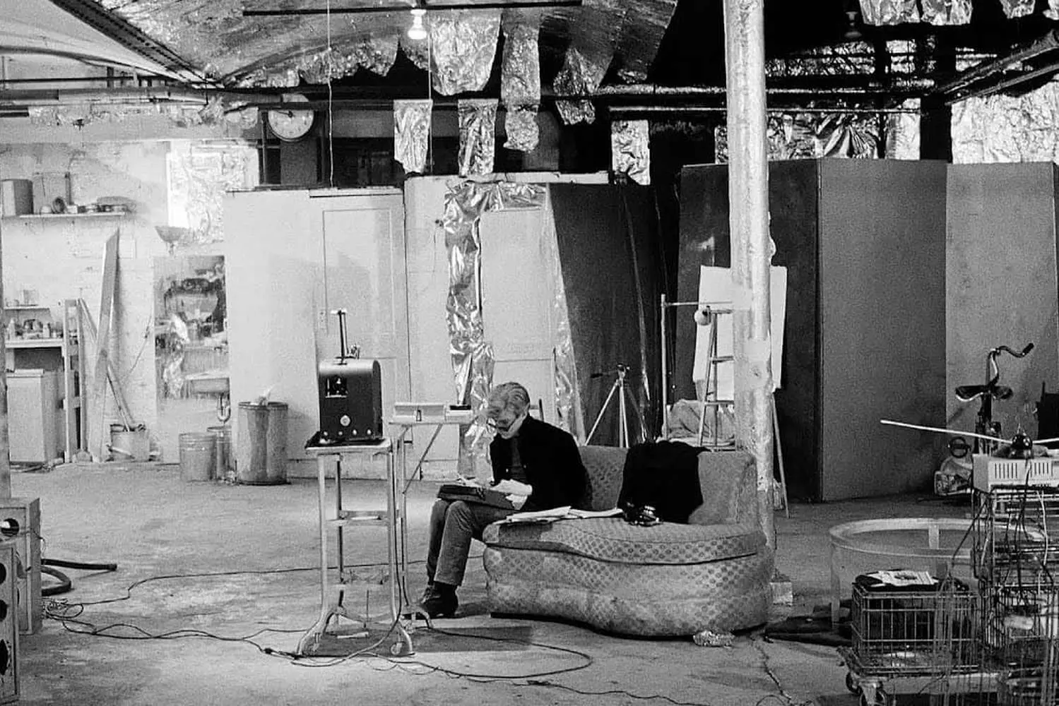 Andy Warhol at The Factory: Inside His Legendary Silver Studio Andy Warhol poses in his iconic Silver Factory studio surrounded by artworks and collaborators, capturing the creative chaos of his 1960s New York art space that revolutionized pop culture