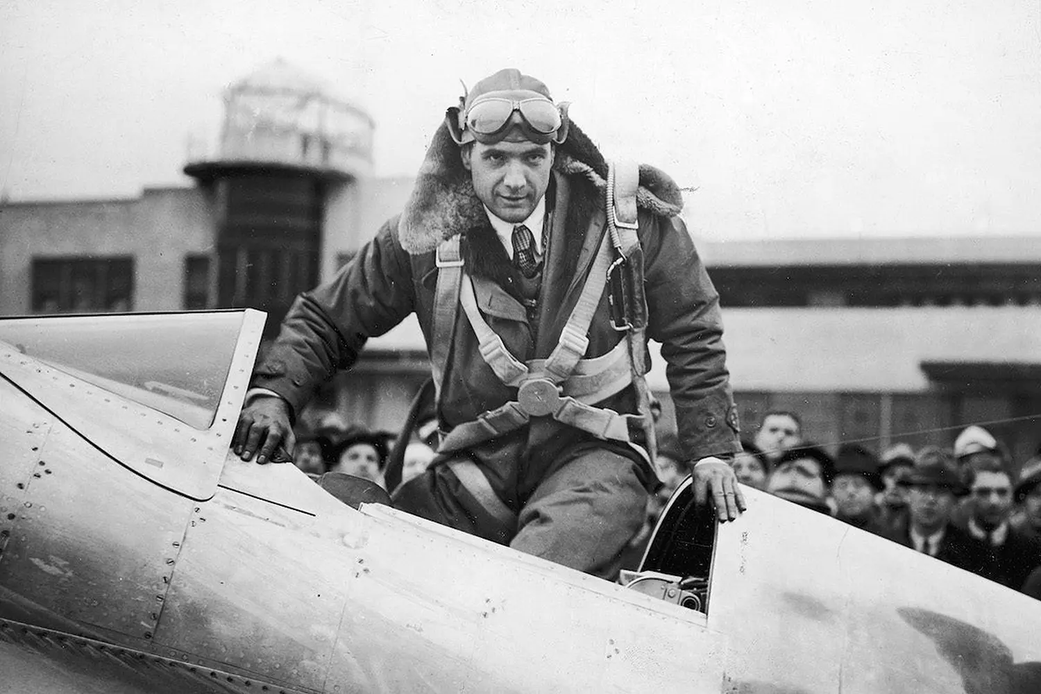 Howard Hughes Emerges from His Masterpiece — The Man Who Defied Gravity" Black and white photo of Howard Hughes climbing out of a vintage aircraft cockpit, his determined expression capturing his passion for aviation and innovation