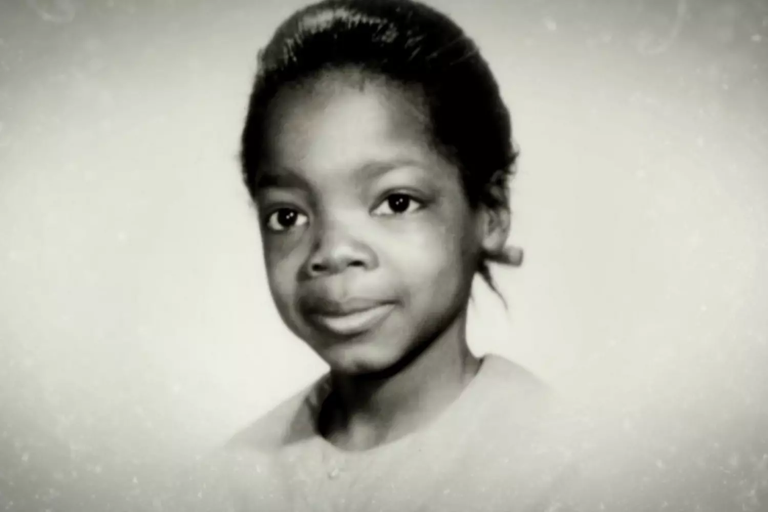 Из маленькой девочки в икону: Скромное начало Опры Уинфри Черно-белое фото улыбающейся маленькой Опры Уинфри