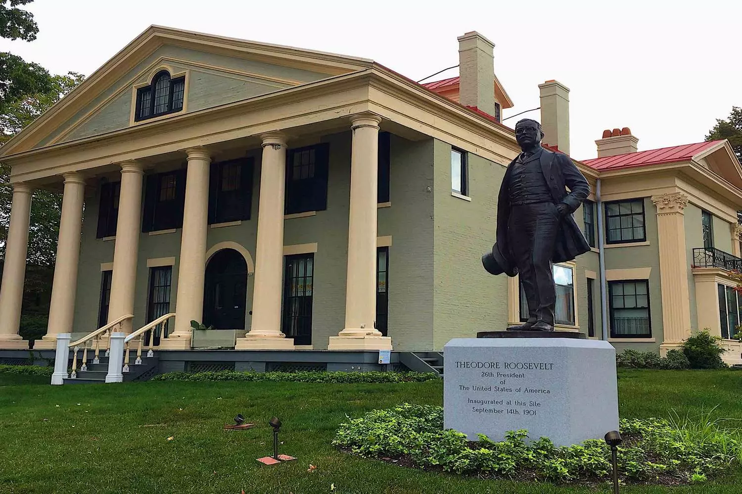 Theodore Roosevelt Statue in Front of Historic Building: Connecting Eras Bronze statue of Theodore Roosevelt standing before an old building facade