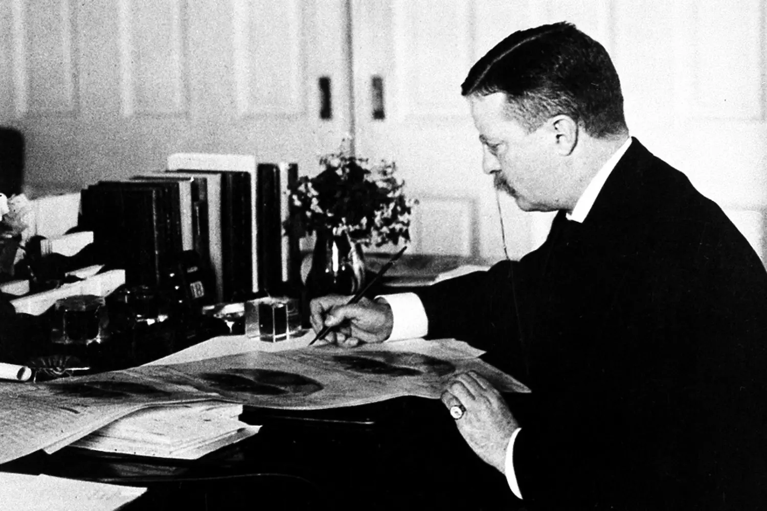 Theodore Roosevelt at Work: The Scholar President in His Study Theodore Roosevelt seated at a large desk, deeply engrossed in work