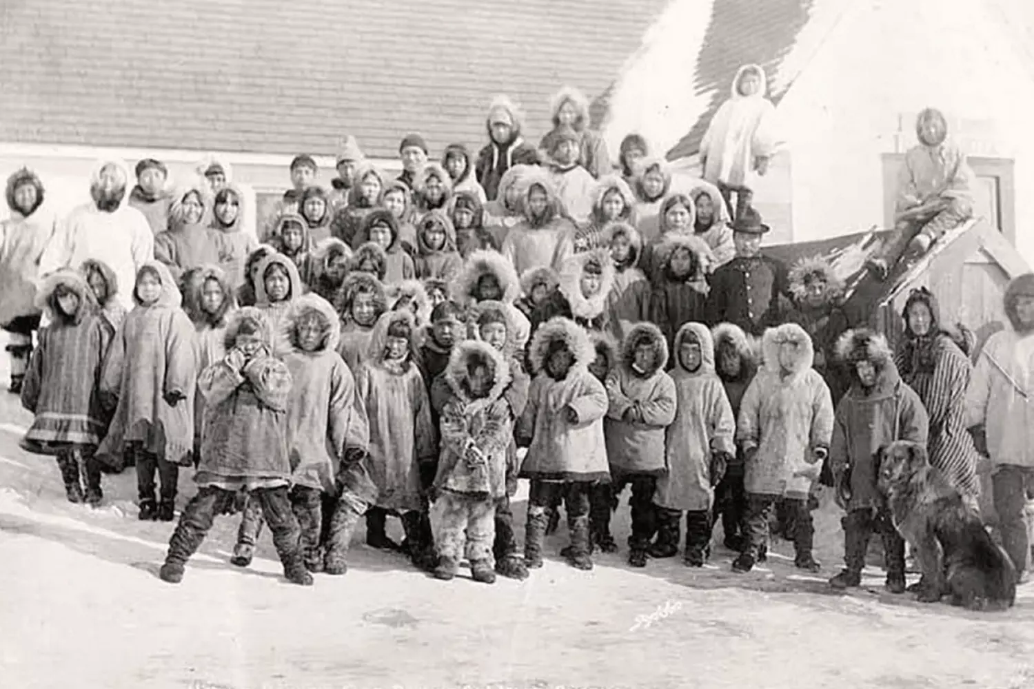 Inuit Heritage: A Glimpse into Alaska’s Indigenous Past Historical black-and-white photograph of Inuit elders in traditional fur clothing, standing against an Arctic landscape, preserving the cultural legacy of Alaska’s indigenous people