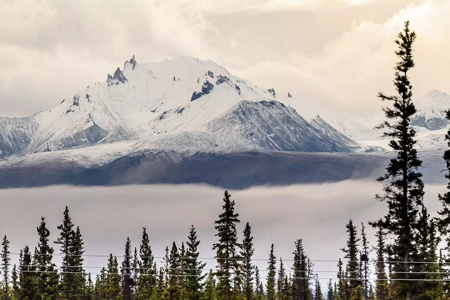 Alaska's Untamed Beauty: Landscapes That Take Your Breath Away Panoramic view of Alaska's rugged wilderness with towering snow-capped mountains, turquoise glaciers, and endless evergreen forests under a dramatic cloudy sky