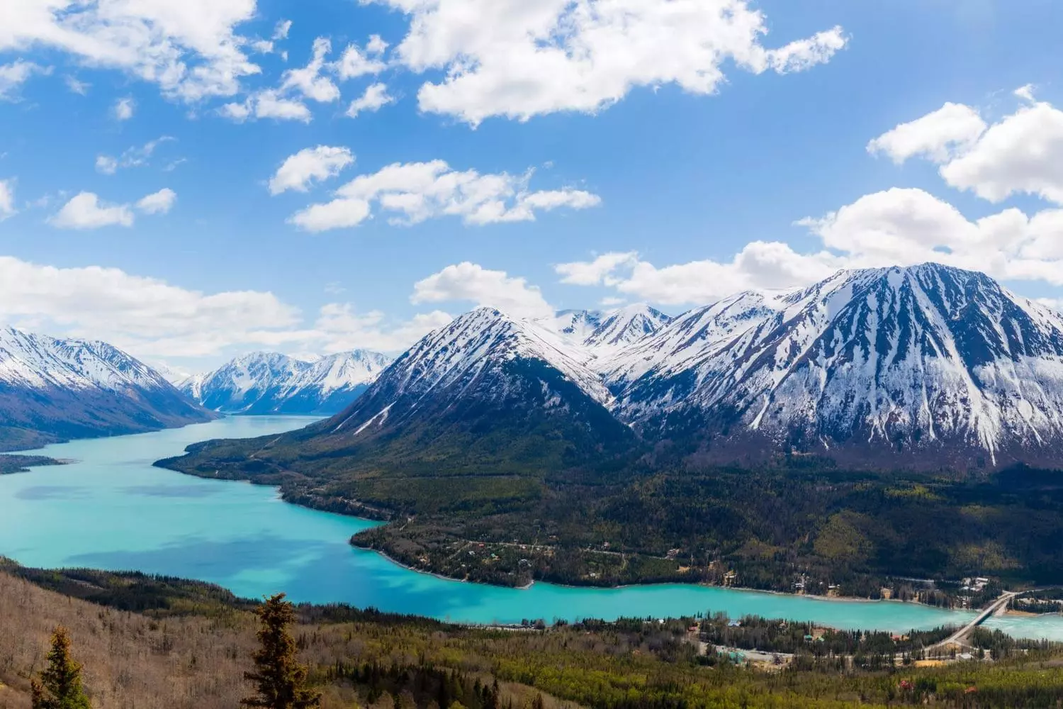 Alaska's Untamed Beauty: Landscapes That Take Your Breath Away Panoramic view of Alaska's rugged wilderness with towering snow-capped mountains, turquoise glaciers, and endless evergreen forests under a dramatic cloudy sky