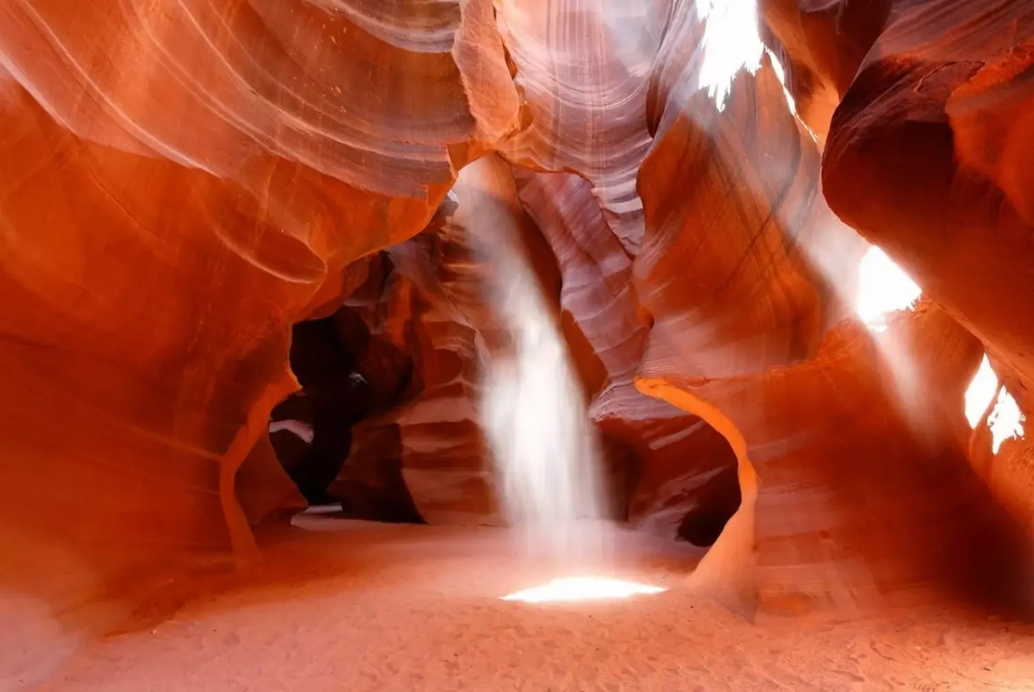 Antelope Canyon, Arizona: Nature’s Light Sculpture Sunlight streaming through the narrow sandstone walls of Antelope Canyon, creating hypnotic, wave-like patterns on the orange rocks