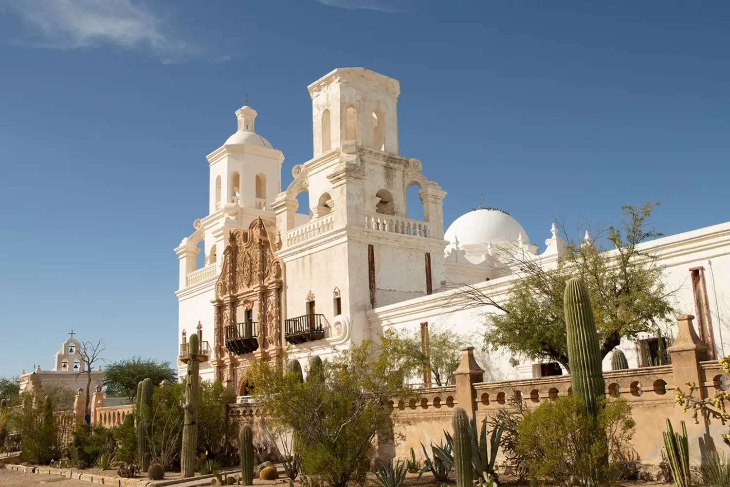 Mission San Xavier del Bac: The White Dove of the Arizona Desert The facade of the historic Mission San Xavier del Bac, adorned with intricate white stucco and twin bell towers under the bright Arizona sky