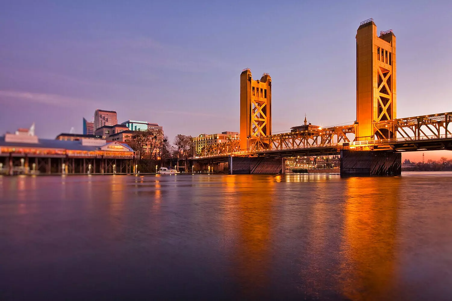 Golden Tower Bridge across the Sacramento River in California's capital city during the day, view of lift towers and water