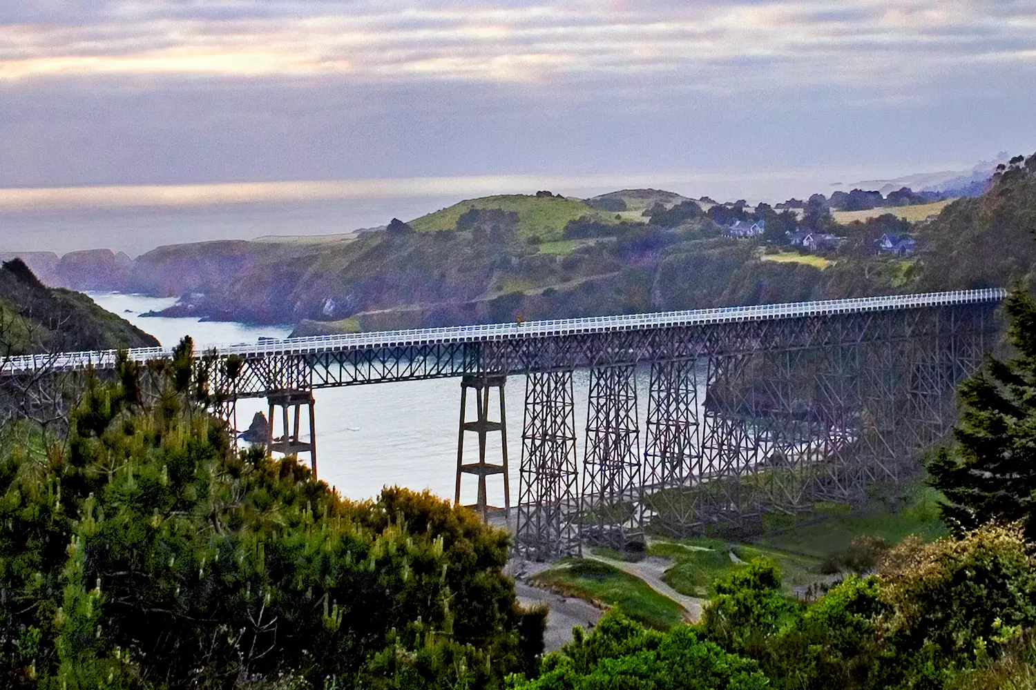 Wooden Albion River Bridge on Highway 1 in Mendocino County, California, during the day with green hills in the background
