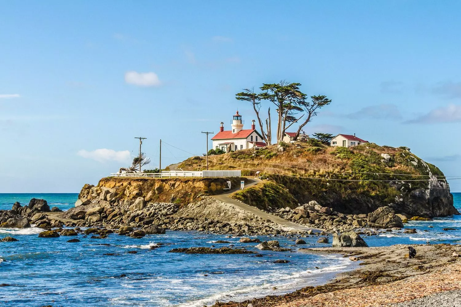 Battery Point Lighthouse against the Pacific Ocean and rocky coastline of Crescent City