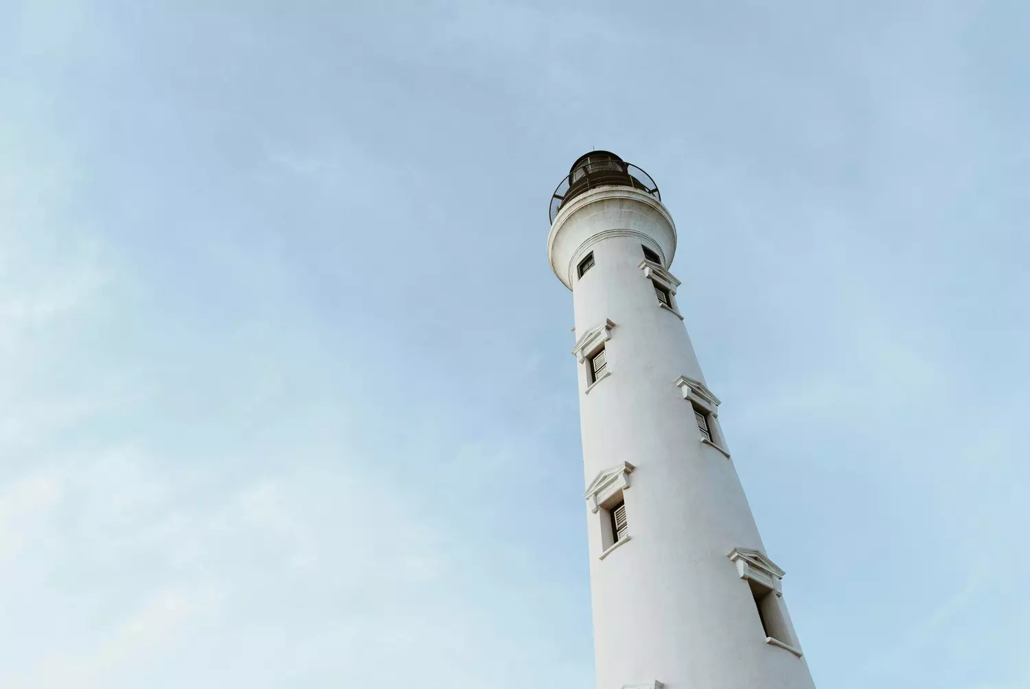 Tall white California lighthouse tower stretching vertically into the sky