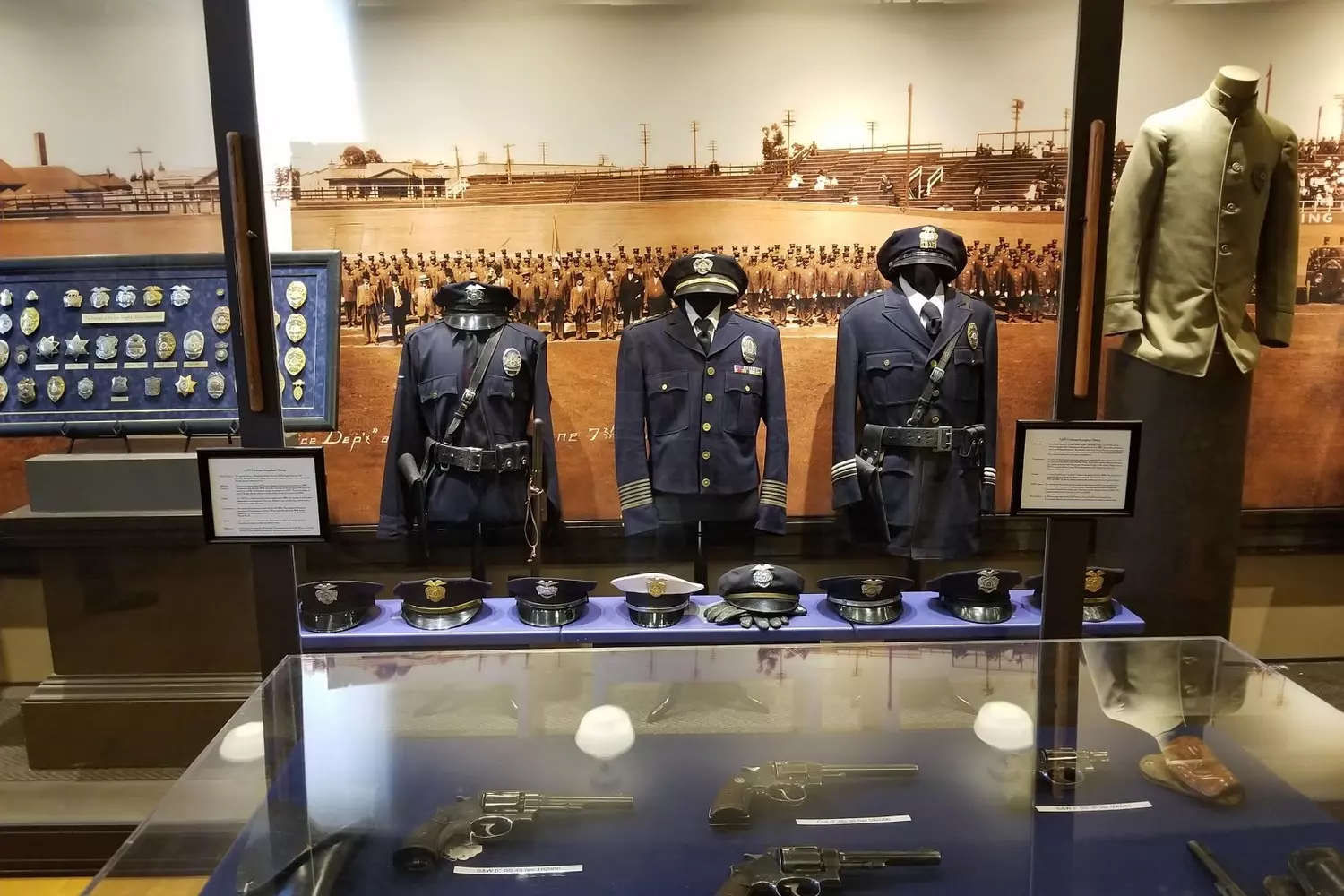 Los Angeles Police Museum exhibition: historical police uniforms and firearms displayed in glass cases