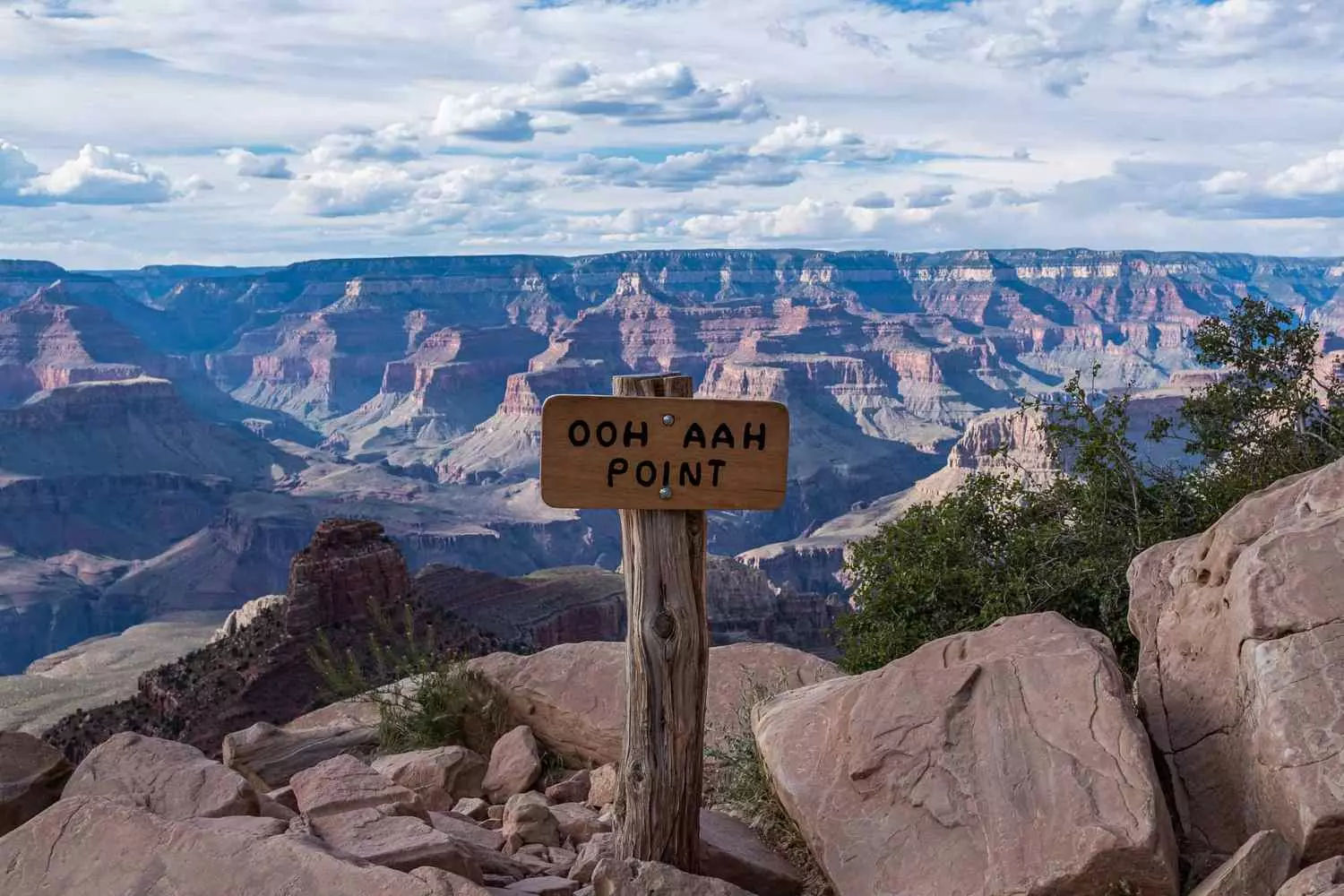 Ooh Aah Point: самый фотогеничный вид Гранд-Каньона Туристы на смотровой площадке Ooh Aah Point с панорамным видом на многослойные красные скалы Гранд-Каньона в солнечный день