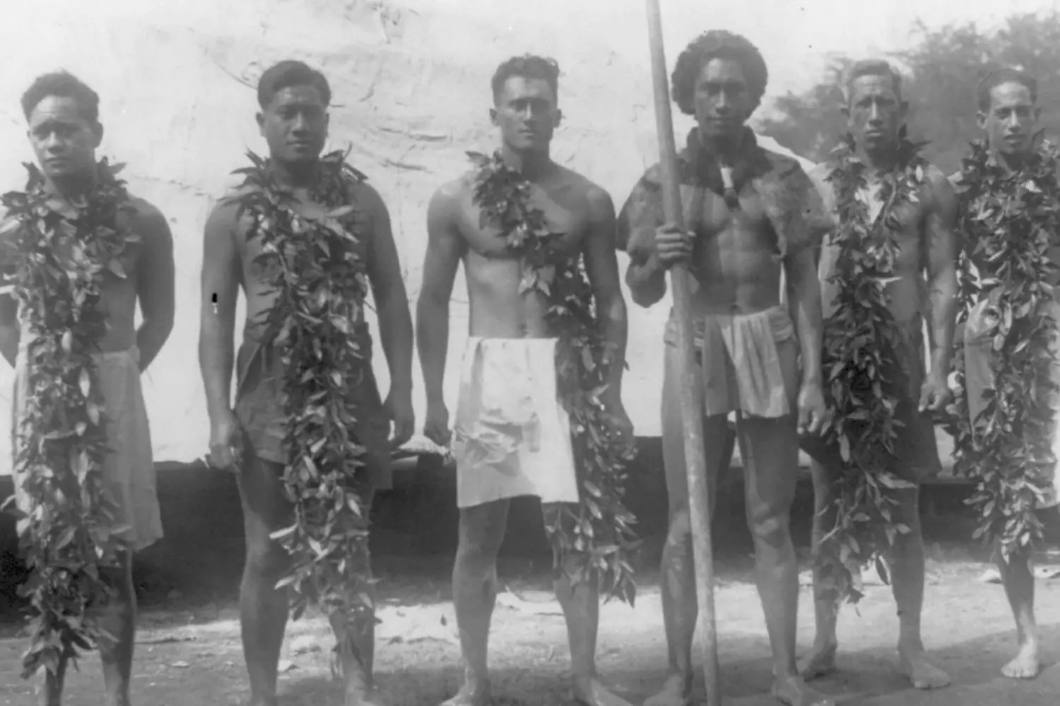 Vintage Portrait of Native Hawaiians in Traditional Clothing Black and white historical photo of Native Hawaiian men and women posing in traditional kapa cloth garments and lei, showcasing pre-colonial culture