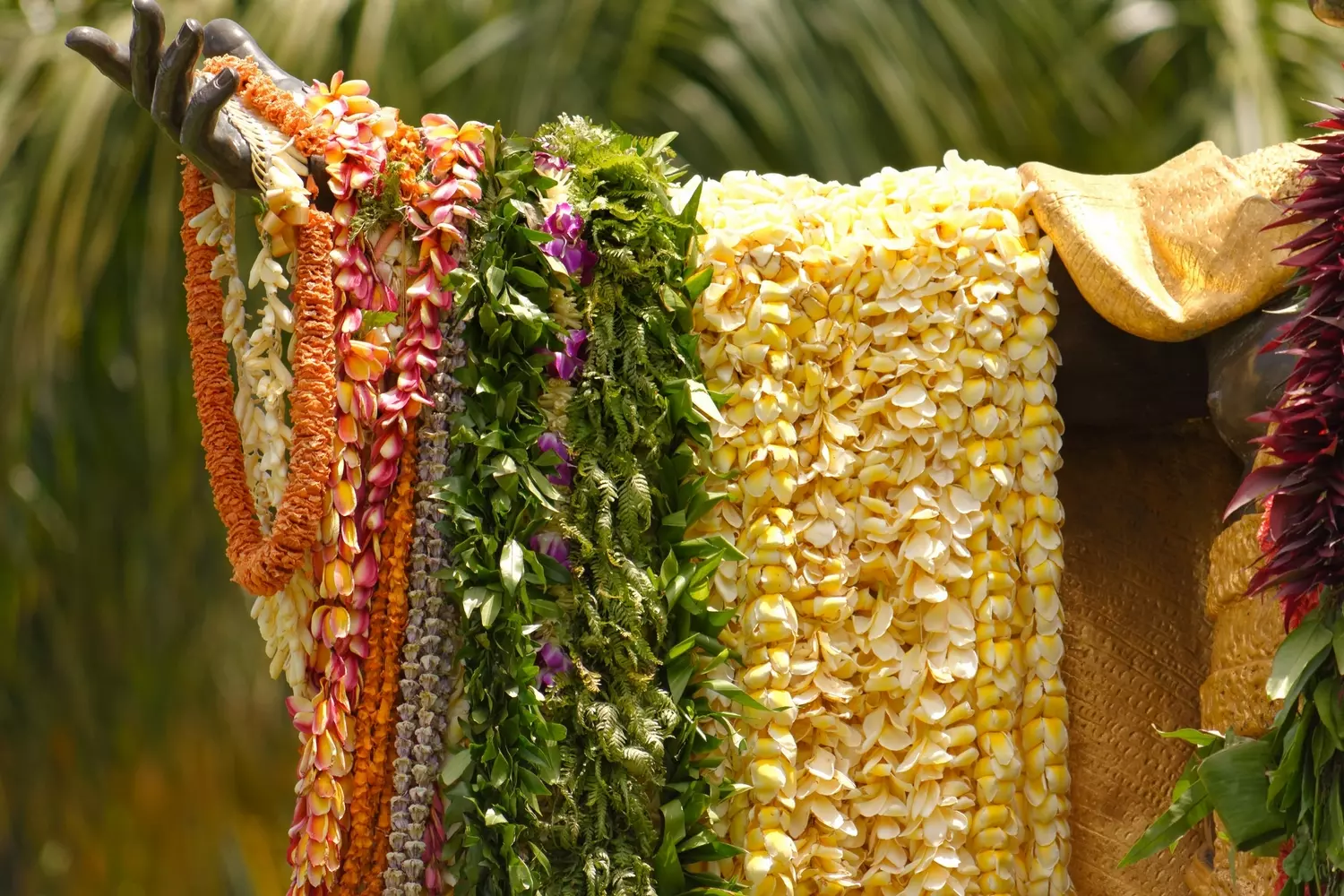 Handmade Hawaiian Flower Leis: Traditional Garland Symbolism Close-up of vibrant, freshly made traditional Hawaiian leis (flower garlands) featuring plumeria, orchids, and green leaves, arranged on a surface