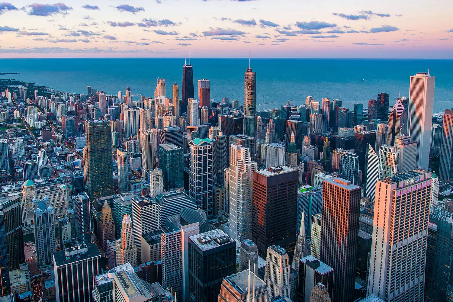 Chicago From Above: The Stunning Bird's-Eye View of Illinois' Crown Jewel Aerial view of Chicago skyline with iconic skyscrapers along Lake Michigan shoreline, showcasing the city's architectural grandeur from above