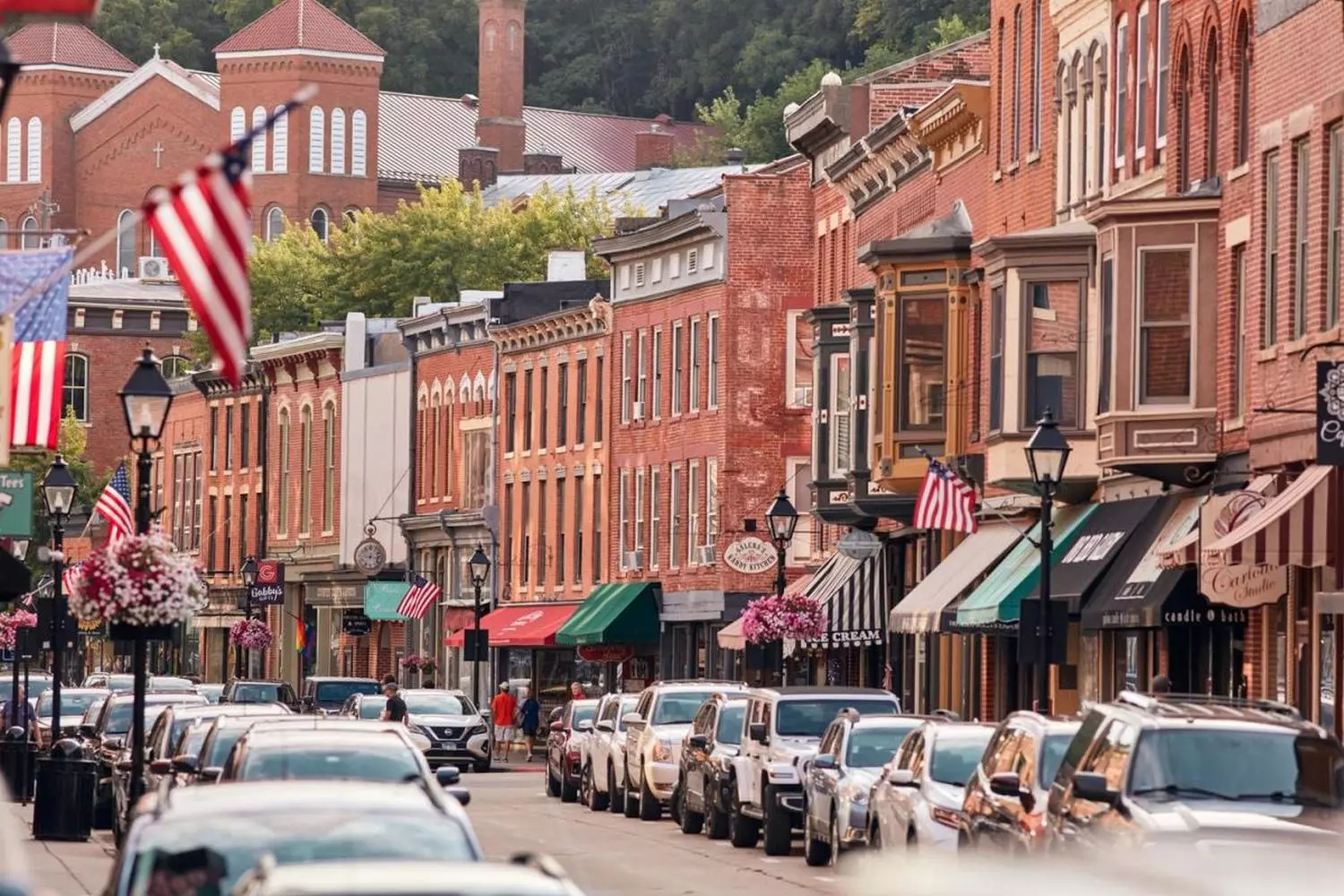 Timeless Charm: Wandering Through Illinois' Historic Small-Town Streets Quaint historic street in an Illinois small town featuring vintage brick buildings, old-fashioned lampposts, and blooming flower boxes under a clear blue sky with few pedestrians strolling along the sidewalk
