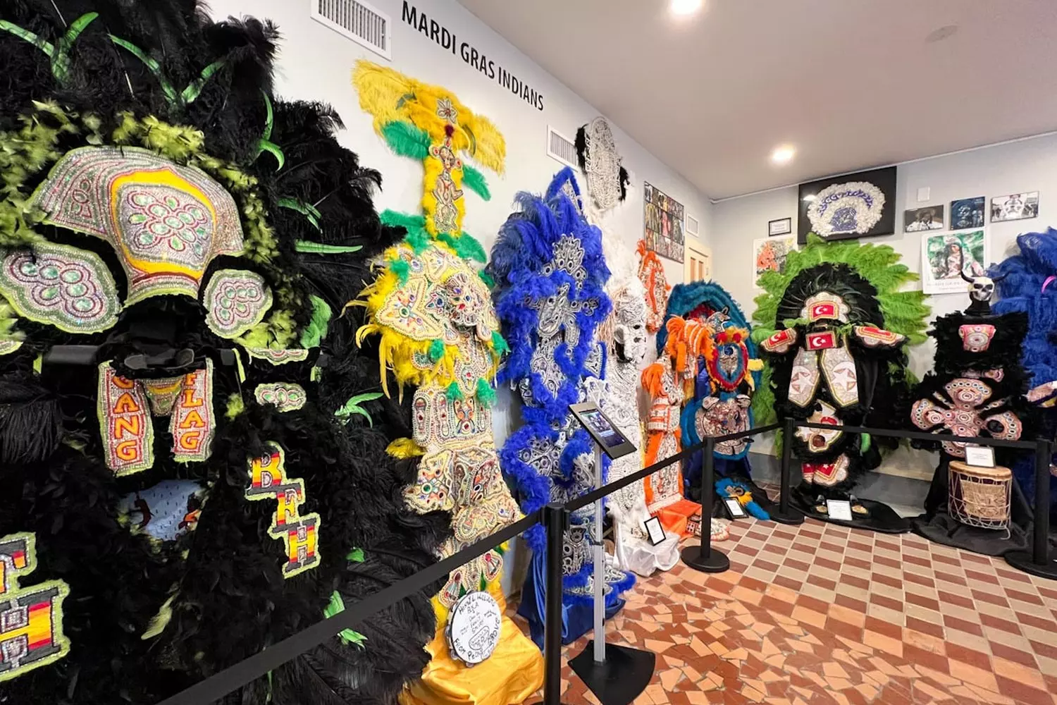 Костюмы Mardi Gras Indians в Backstreet Museum Вдоль стены в Backstreet Cultural Museum вплотную друг к другу висят десятки костюмов Mardi Gras Indians