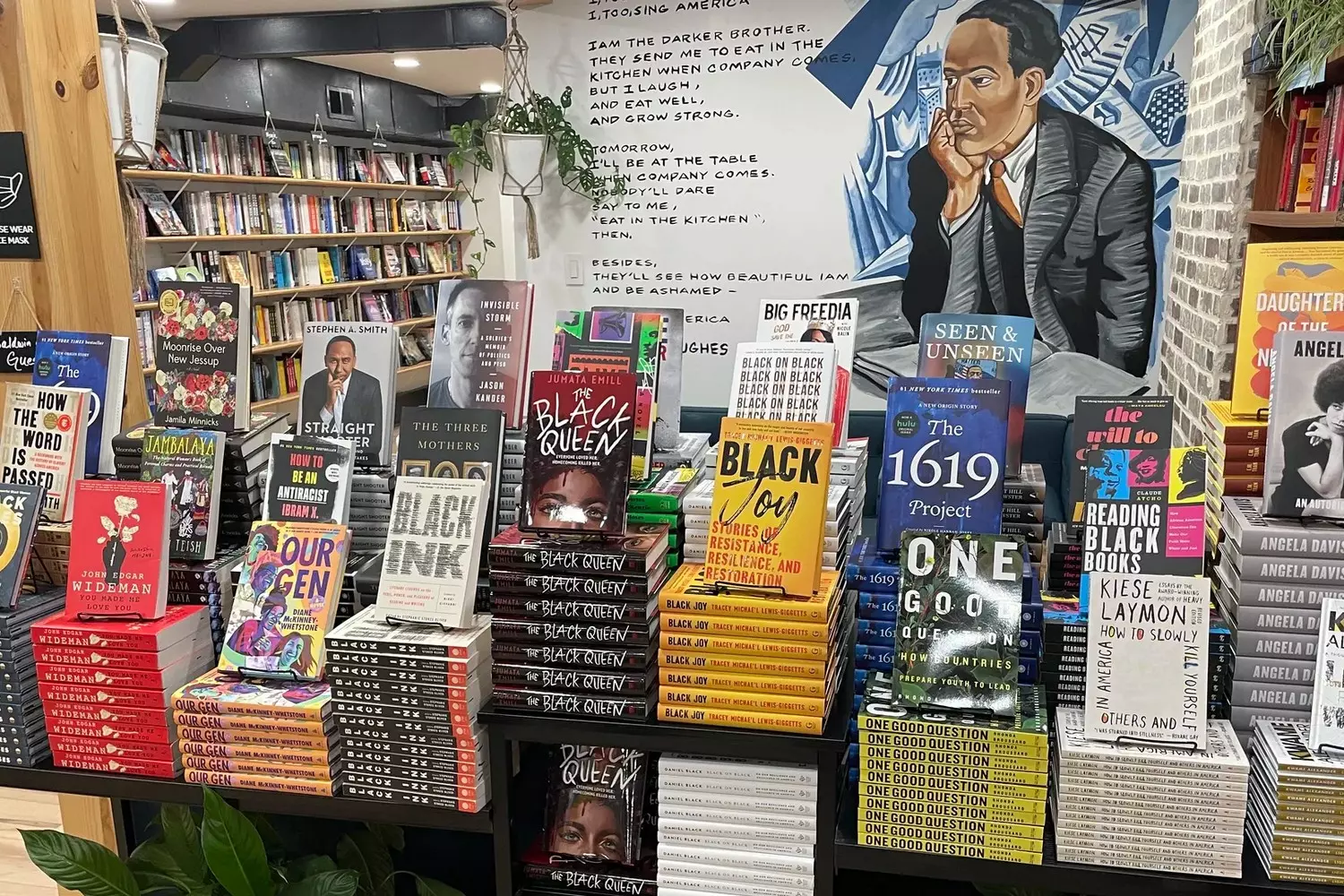 Стенд книжной выставки ESSENCE Authors на Essence Festival, стеллажи с книгами черных авторов, посетители знакомятся с новинками литературы