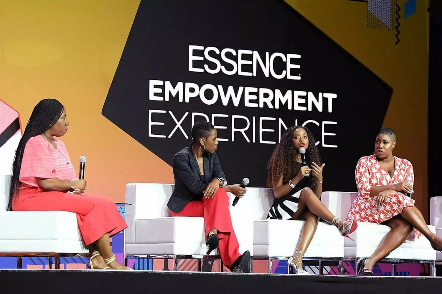 Участники дискуссии на сцене Essence Empowerment Experience в Новом Орлеане, спикеры обсуждают вопросы предпринимательства и благополучия, аудитория в зале