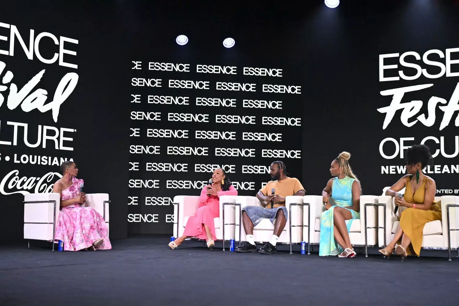 Женщины-спикеры на сцене Essence Festival обсуждают лидерство, силу сообщества и расширение прав и возможностей, аудитория в зале