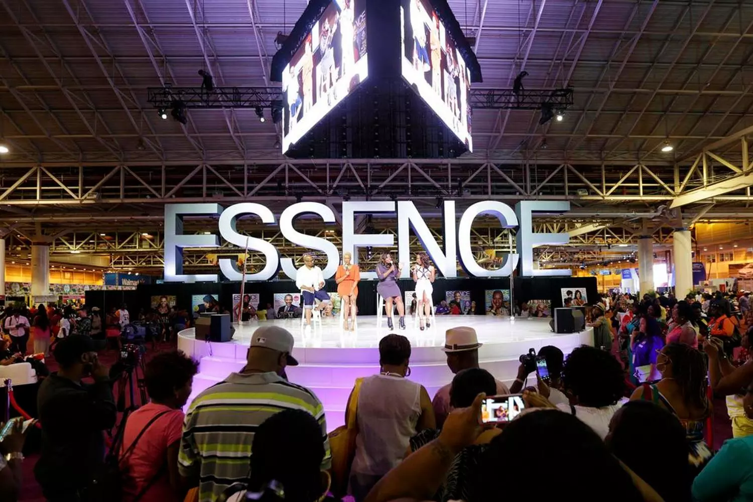 Спикеры на сцене Essence Festival обсуждают предпринимательство и бизнес-стратегии, аудитория в деловых костюмах, зал для конференций