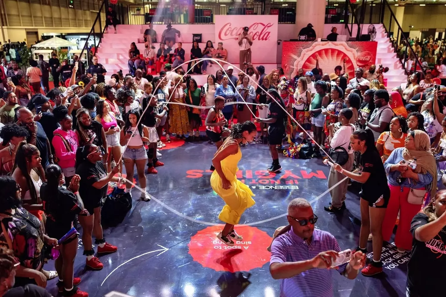 Посетители Essence Festival прыгают через скакалку во время утренней зарядки на главной сцене, яркая и энергичная атмосфера