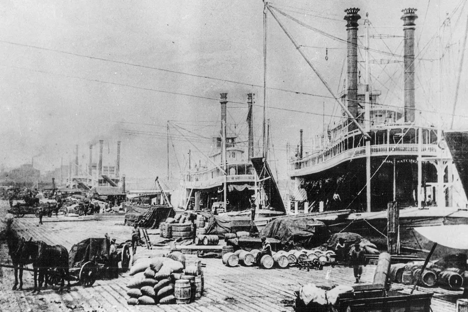 Историческая фотография порта Нового Орлеана на реке Миссисипи, конец XIX века — пароходы, баржи и суда у набережной на фоне городских зданий