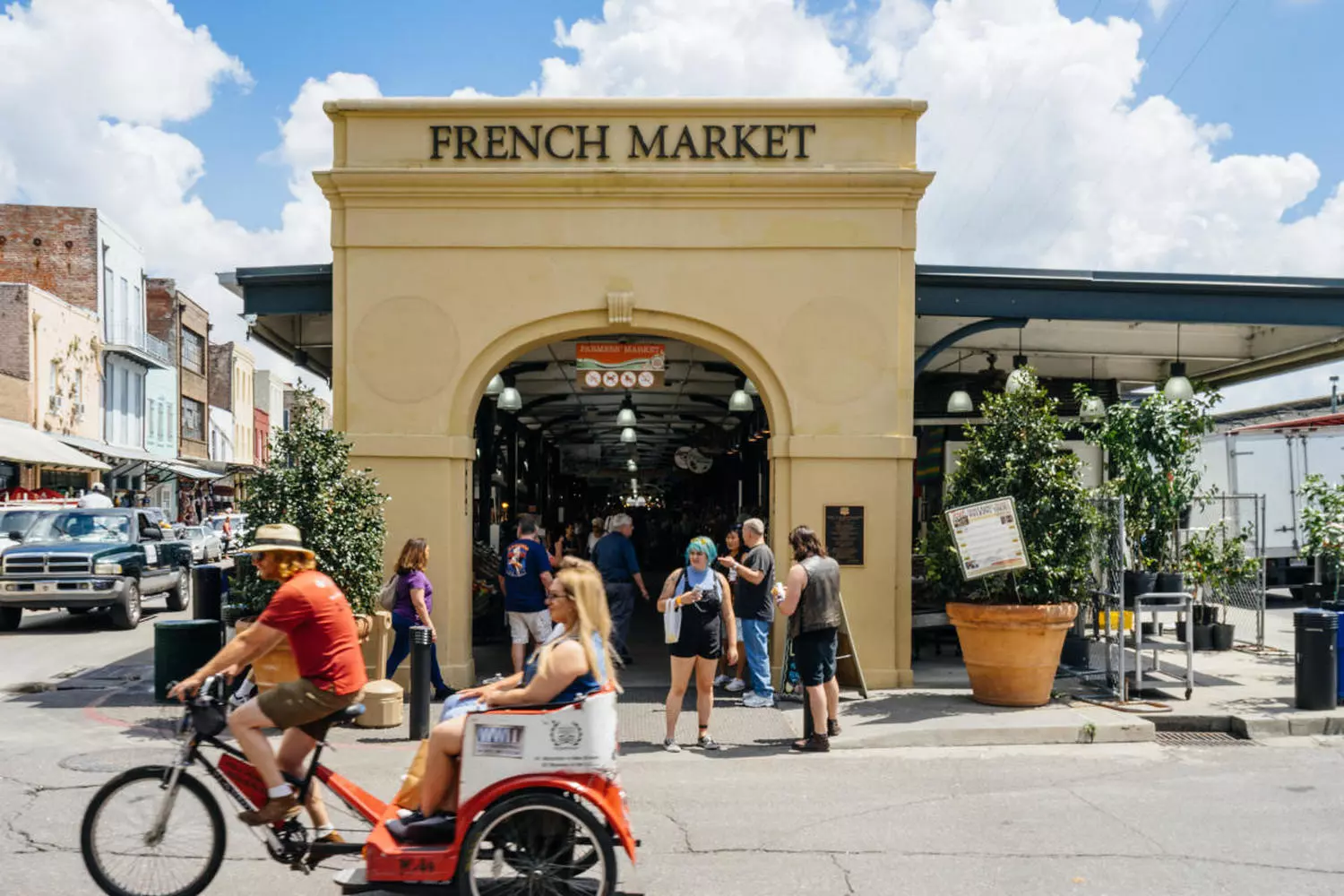 Вход на Французский рынок в Новом Орлеане: кованая арка с вывеской French Market на фоне неба и уличных фонарей