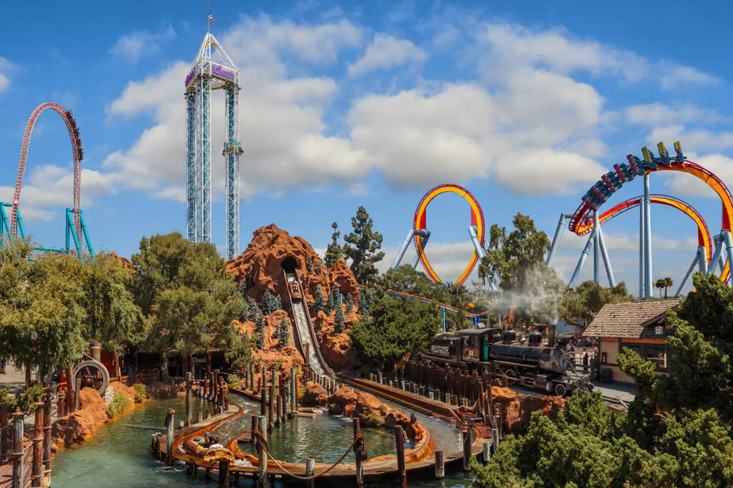 Wild Rides & Old West Charm: Knott's Berry Farm Adventure Knott's Berry Farm's iconic GhostRider wooden roller coaster twisting through the park with its massive timber structure, surrounded by old-west style buildings and happy riders