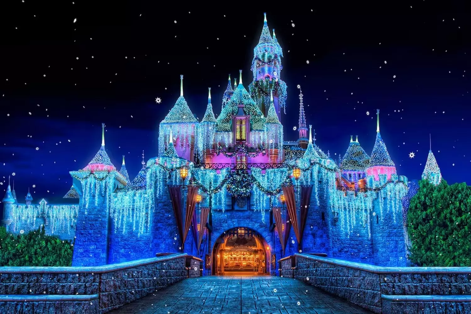 Enchanted Nights: Disneyland's Iconic Castle Aglow with Magic Cinderella Castle at Disneyland illuminated with thousands of sparkling lights, reflecting in the surrounding moat during an evening fireworks show
