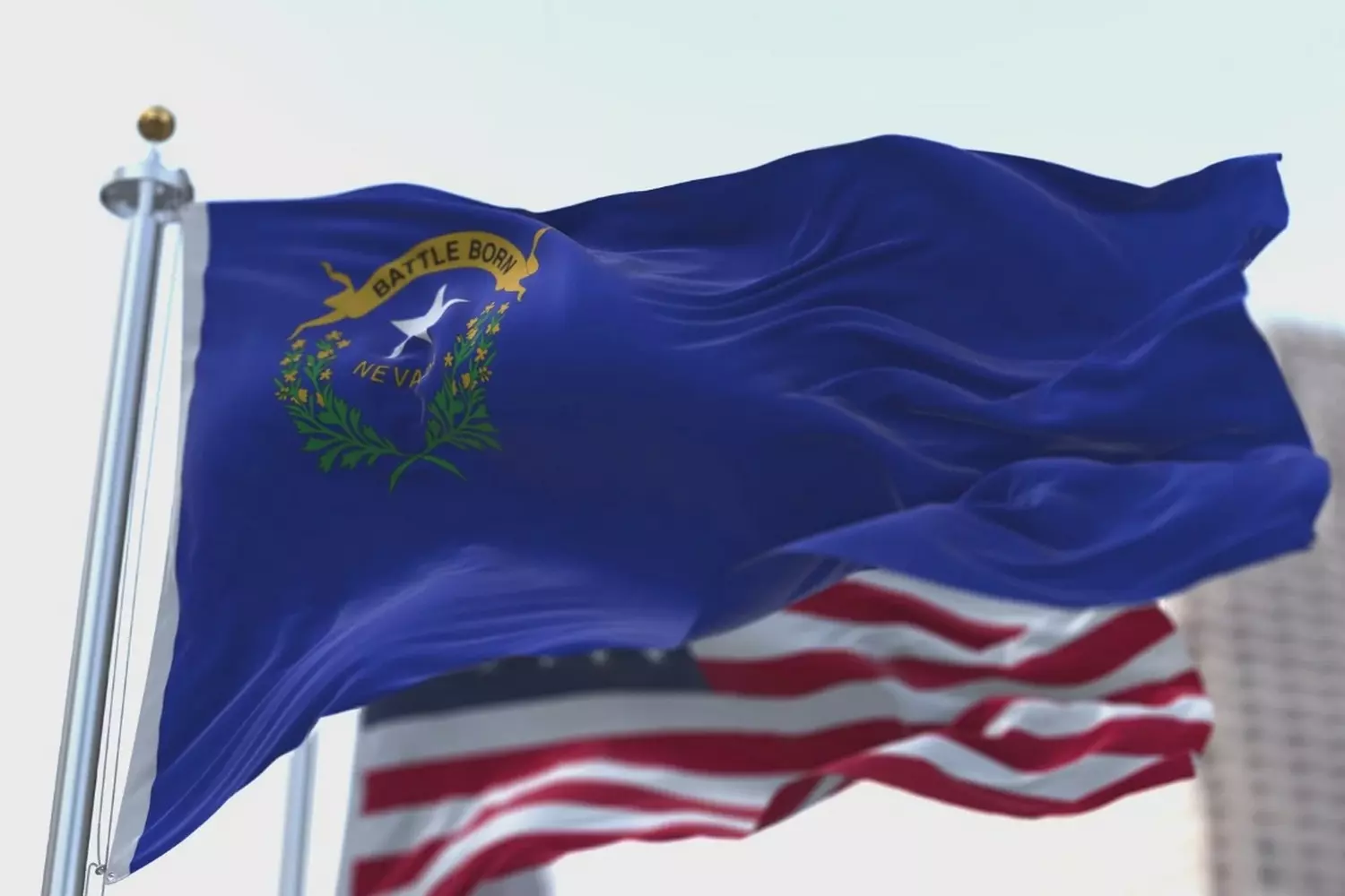 The U.S. and Nevada state flags flying side by side Flags of the United States and Nevada waving together