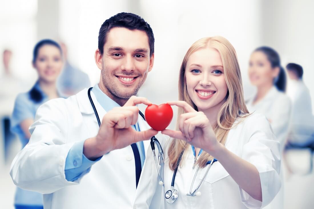 Кардиологи США — фото пара докторов с макетом здорового сердца в руках — American Butler