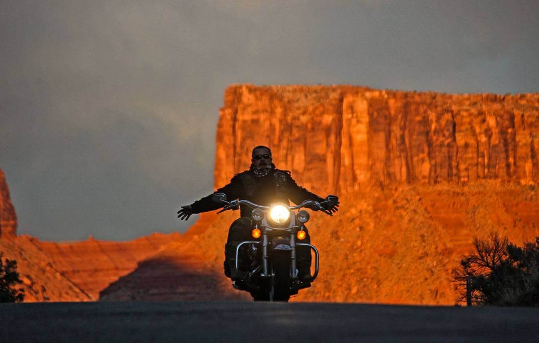 Biker rides through the Mojave Desert in Nevada on a Harley-Davidson motorcycle — American Butler
